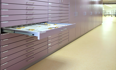 White medical furniture with many drawers and medical equipment inside.