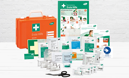 A photo of an orange first aid box containing a set of bandages, patches, gloves and other needed elements