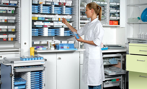 A young woman with blonde hair and lab coat, preparing and segregating drugs.
